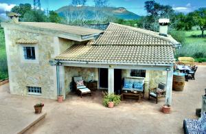 a stone house with chairs and a patio at Finca Can Titos in Llucmajor