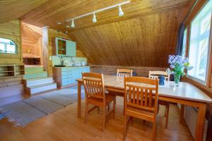 Una cocina y un comedor con mesa y sillas de madera. en Villa Rentola, en Pääjärvi