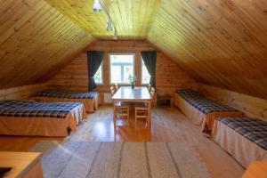 a room with three beds and a table in a attic at Villa Rentola in Pääjärvi