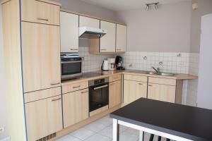 a kitchen with wooden cabinets and a black counter top at De Wilgoren in Kasterlee