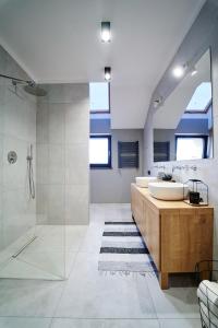 a bathroom with two sinks and a walk in shower at LOFT Apartment in Suwałki