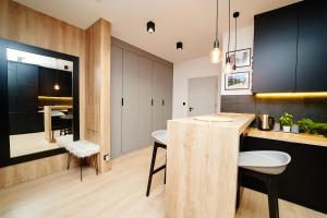 a kitchen with a wooden counter and a dining room at LOFT Apartment in Suwałki