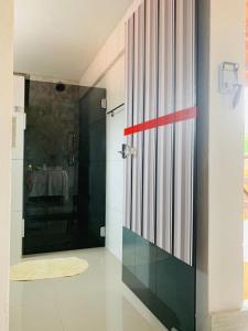 a bathroom with a shower and a glass door at Pousada O Rancho Alegre in Moreré