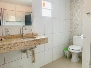 La salle de bains est pourvue d'un lavabo et de toilettes. dans l'établissement Pousada O Rancho Alegre, à Moreré