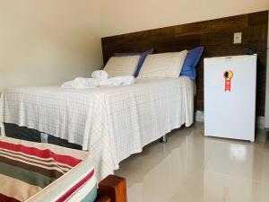 1 dormitorio con 1 cama y nevera pequeña en Pousada O Rancho Alegre en Moreré