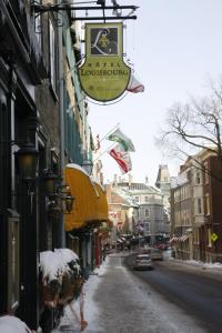 a sign for a restaurant on a street covered in snow at Hotel Louisbourg in Quebec City