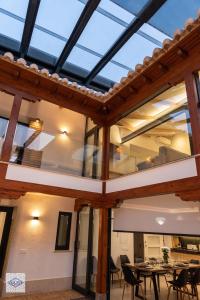 a conservatory with a glass roof with tables and chairs at Ágora Casa in Almagro