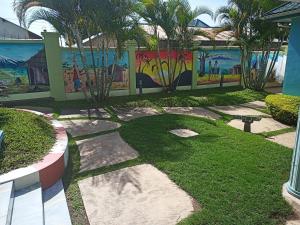 ein Garten mit einer Mauer, auf der ein Gemälde prangt in der Unterkunft Blue sky Hotel in Mwanza