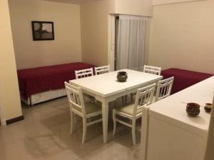 Departamentos Premium - 2 Ambientes - Excelente ubicación في ميرامار: طاولة بيضاء وكراسي في غرفة المعيشة