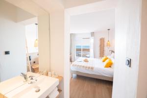a bedroom with a bed and a bathroom with a mirror at Hôtel Casa Marina in Saintes-Maries-de-la-Mer +84 photos