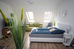 a bedroom with a bed and a couch at Kossuth Apartmanház in Tata