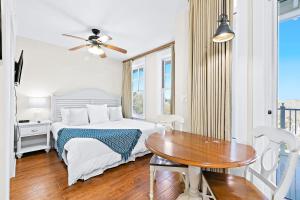
a bedroom with a bed, chair, table and a window at Sandestin Baytowne Wharf - Observation Point South #471 in Destin
