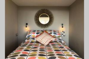 a bedroom with a bed with a mirror on the wall at Wilderness Lodge in Oswestry