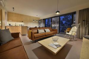 a living room with a couch and a table at Element Lakeside Apartments in Lipno nad Vltavou
