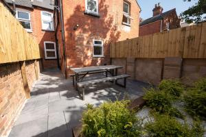 a patio with a wooden fence and a bench at Franklin Lodge in Reading