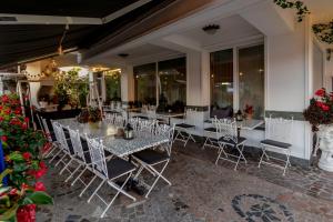 a group of tables and chairs on a patio at Jagodic Garni Hotel in Cerklje na Gorenjskem
