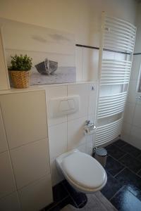 a bathroom with a toilet and a picture of a boat at Ferienwohnung HeideZeit Soltau - Neu mit Spielturm in Soltau