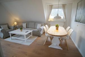 a living room with a table and a couch at Ferienwohnung HeideZeit Soltau - Neu mit Spielturm in Soltau