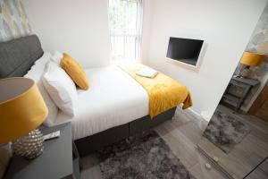 a bedroom with a bed with a yellow blanket at Franklin Lodge in Reading +9 photos