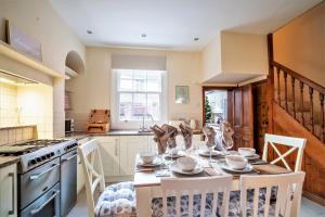 a kitchen with a table and chairs and a kitchen with a stove at The Cottage in Chester, Sleeps 6 with FREE Parking in Chester