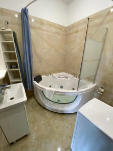 a bathroom with a bath tub and a sink at Welcome Apartments Center in Kyiv