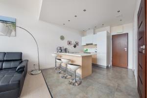 a kitchen and living room with a counter and a couch at Apartamenty Sun & Snow Dune A in Mielno