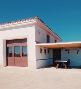 Vila Triana I Lea- Loft Rural في سانت كارليس دي لا رابيتا: بيت ابيض ومقعد امامه