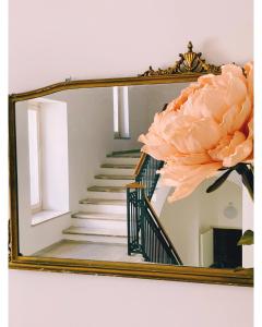 a mirror with a staircase and a pink flower at Dimora Pardo in Larino