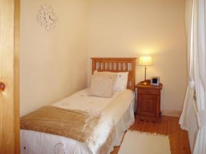 a bedroom with a bed and a night stand with a lamp at Clydagh Lodge in Castlebar