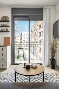 a living room with a table and a large window at Mr. Agrippa - By TLV2GO in Jerusalem