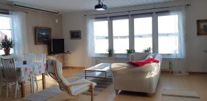 a living room with a table and chairs and windows at Nivagården in Korpikylä