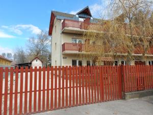 una cerca roja frente a una casa en Margaréta Apartmanház en Balatonlelle