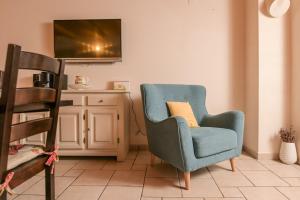a living room with a blue chair with a yellow pillow at Villa Plasa Krk in Kras