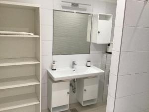bagno bianco con lavandino e specchio di Apartments Tomato a Novigrad Istria
