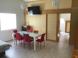 ein Esszimmer mit einem Tisch und roten Stühlen in der Unterkunft Apartments Tomato in Novigrad Istria