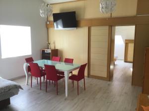 a dining room with a table and red chairs at Apartments Tomato in Novigrad Istria