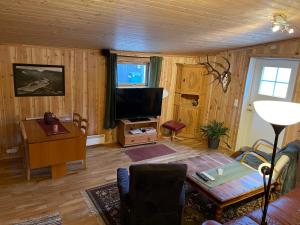 sala de estar con TV y mesa en Signegarden - Midt i fjellheimen - Tett på Fjord-Norge, en Skjåk