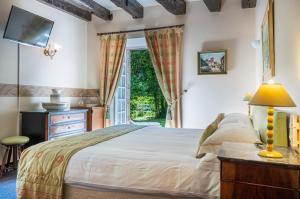 1 dormitorio con cama y ventana en Au Moulin de La Gorce, en La Roche-lʼAbeille