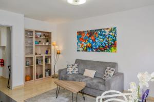 a living room with a couch and a painting on the wall at Cosy apartment in the hypercentre of Avignon in the Provence- Welkeys in Avignon