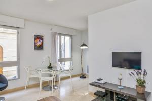 a white living room with a table and chairs at Cosy apartment in the hypercentre of Avignon in the Provence- Welkeys in Avignon