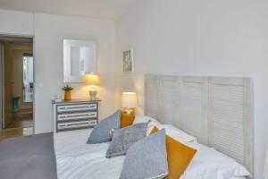 una camera da letto con un grande letto bianco con cuscini di Cosy apartment in the hypercentre of Avignon in the Provence- Welkeys ad Avignone