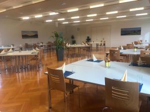a large room with tables and chairs in it at Dialoghotel Eckstein in Zug