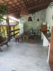 a kitchen with a table and a refrigerator in a room at Aruá Observação de aves e natureza in Praia do Forte
