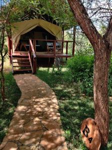 Kajiado的住宿－Oldonyo Orok Lodge，凉亭,配有桌子和树