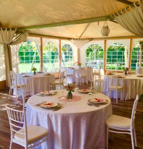 a room with tables and chairs with white table cloth at Agriturismo Le Grotte in Nemi