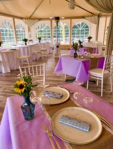 une tente avec tables, chaises et nappes violettes dans l'établissement Agriturismo Le Grotte, à Nemi