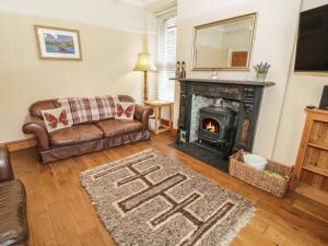 a living room with a couch and a fireplace at Ty Capel in Betws-y-coed