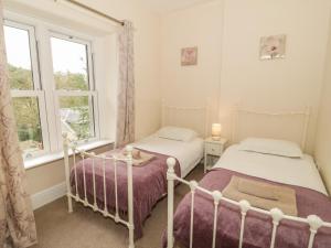 two beds in a bedroom with a window at Ty Capel in Betws-y-coed