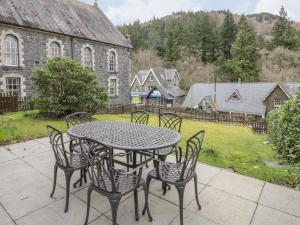 a table and chairs on a patio with a yard at Ty Capel in Betws-y-coed