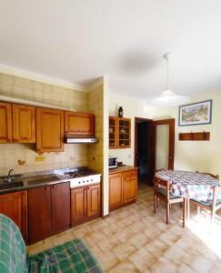 eine Küche mit Holzschränken und einem Tisch darin in der Unterkunft Ambra in Bibione
